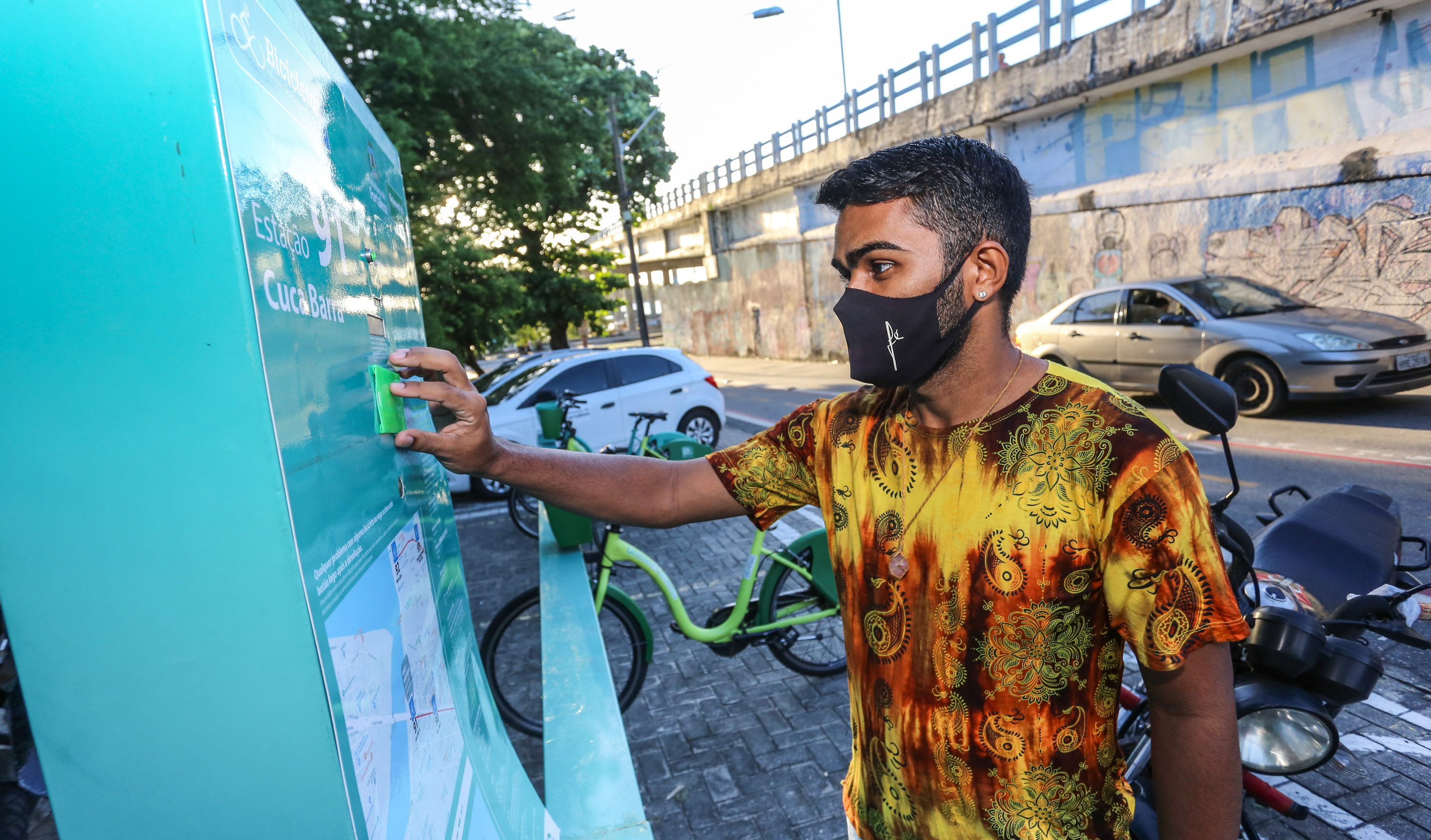 rapaz passa o cartão numa estação do bicicletar